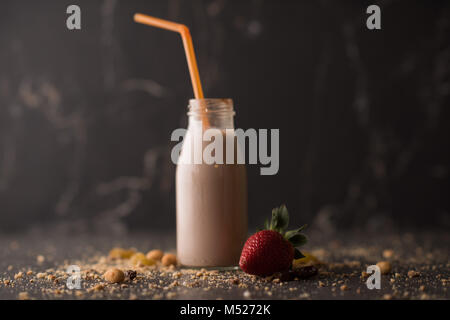 Milk in bottle with straw on dark stone background Stock Photo