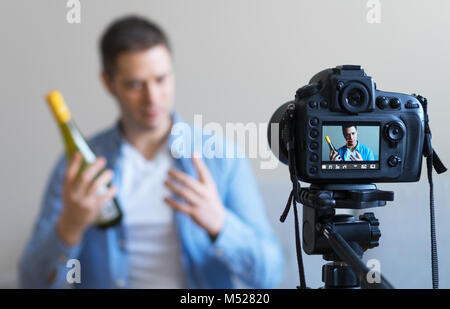 Man making video blog about wine and alcohol. Focus on camera. Stock Photo