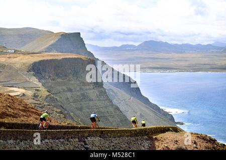 Group of cyclists going downhill on seaside road, Lanzarote, Canary Islands, Spain Stock Photo