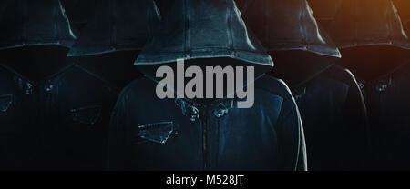 Group of hooded computer hackers with obscured faces lined up in formation as army soldiers. Programmers, internet experts and cybersecurity Stock Photo