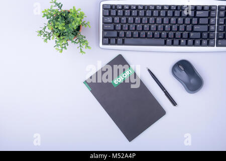 Office table with blank notepad and laptop, supplies and gadgets on desk. Top View. Stock Photo