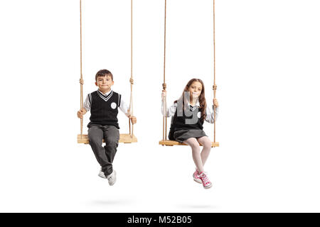 Schoolboy and a schoolgirl sitting on wooden swings isolated on white background Stock Photo