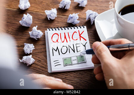Man Drawing Quick Money Concept In Notepad Stock Photo