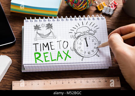 Man Drawing Time To Relax Words In Notepad Stock Photo