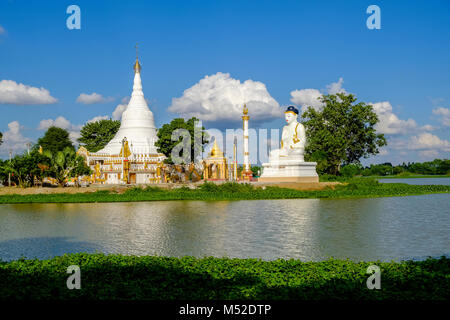 A beautiful white Pagoda and a big white Buddha statue are located on an island in Kan Thar Yar Lake Stock Photo