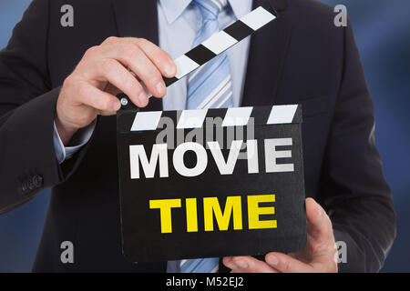 Businessperson Holding Clapboard With Text Movie Time Stock Photo