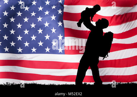 Silhouette Of A Soldier Carrying His Child In Front Of American Flag Stock Photo