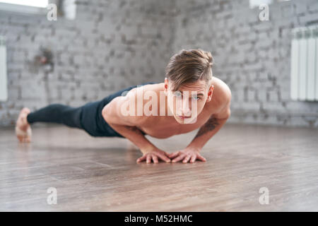 Athletic young man doing push ups on the floor Stock Photo