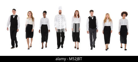 Team Of Happy Restaurant Staffs In Uniform Walking Over White Background Stock Photo