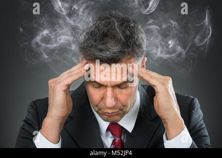 Portrait Of Mature Businessman Suffering From Headache Stock Photo