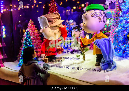 Little girl gazes with wonder at Charlie Brown Christmas window display at flagship Macy's Department Store in New York City, NY, USA. Stock Photo