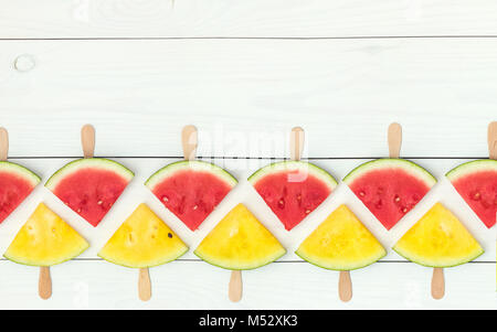 Red and yellow watermelon slices on sticks Stock Photo