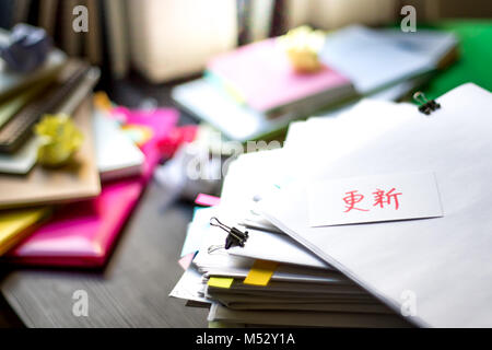 Renew; Stack of Documents. Working or Studying at messy desk. Stock Photo