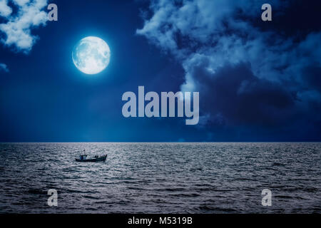 Small fisherman boat  sailing on a full moon night Stock Photo