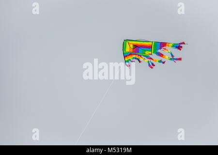 Colourful kite flying high in the sky Stock Photo