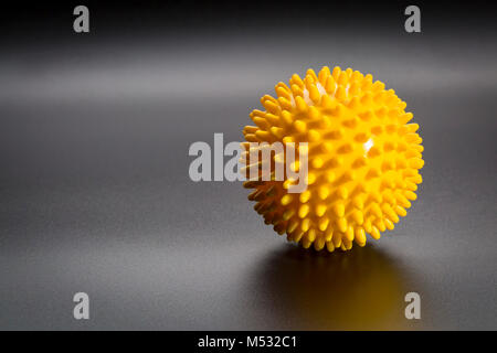 spiky rubber  ball roller for self massage, reflexology and myofascial release, black background with a shadow Stock Photo