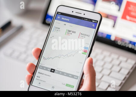 Checking stock market data on a smartphone Stock Photo