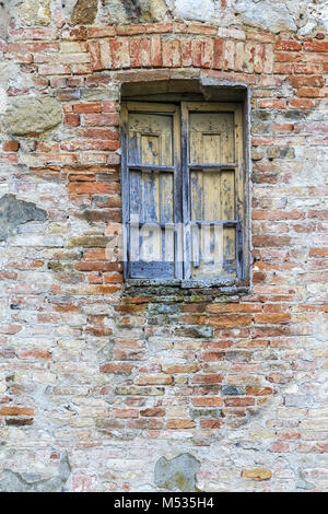 Old weathered window on a brick wall Stock Photo