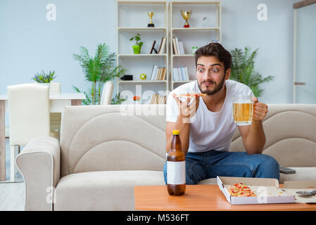 Man eating pizza having a takeaway at home relaxing resting Stock Photo