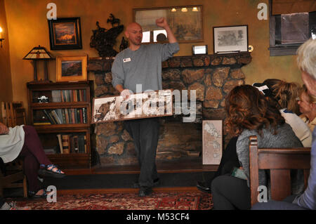 Grand Canyon History Symposium Historic Kolb Studio . View of Phil Payne in living room standing in front of fireplace showing photos of original studio Stock Photo