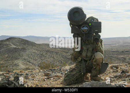 A U.S. Soldier assigned to 2nd Platoon “Bandit Troop”, 1st Squadron, 3rd Cavalry Regiment, scans for simulated enemies at a observation post during Decisive Action Rotation 18-04 at the National Training Center in Fort Irwin, Calif., Feb. 10, 2018. Decisive Action Training Exercises at the National Training Center ensure units remain versatile, responsive, and consistently available for current and future contingencies. (U.S. Army photo by Spc. Esmeralda Cervantes, Operations Group, National Training Center) Stock Photo