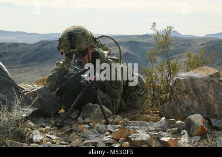 A U.S. Soldier assigned to 2nd Platoon “Bandit Troop”, 1st Squadron, 3rd Cavalry Regiment, scans for simulated enemies at a observation post during Decisive Action Rotation 18-04 at the National Training Center in Fort Irwin, Calif., Feb. 10, 2018. Decisive Action Training Exercises at the National Training Center ensure units remain versatile, responsive, and consistently available for current and future contingencies.(U.S. Army photo by Spc. Esmeralda Cervantes, Operations Group, National Training Center) Stock Photo