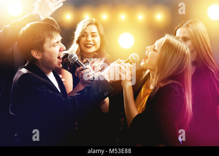 Happy friends are singing and dancing in night club Stock Photo