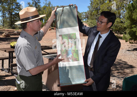 Grand Canyon Renews Sister Park Agreement with China's Yuntaishan World. Jin guibin, Director of Administration at Mt. Yuntai Scenic Area, presents Brian Drapeaux, Deputy Superintendent of Grand Canyon National Park, with a hand-made silk screen print of a scenic view from Yuntaishan Geopark.  Grand Canyon National Park and Yuntaishan Geopark from the Henan province of China renewed their five-year Sister Park Agreement on Tuesday, May 23, 2017.  The agreement allows Stock Photo