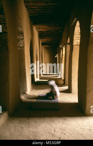 Mali. Timbuktu. Sahara desert. Sahel. Man praying in the Djingareiber Mosque from the 14th century. Oldest mosque in Mali. Unesco World Heritage Site. Stock Photo