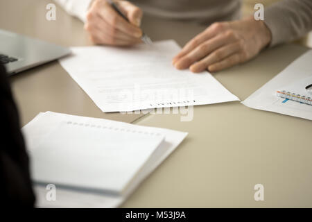 Business leader signing contract document at desk Stock Photo