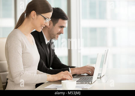 Smiling employees or business leaders using laptop Stock Photo