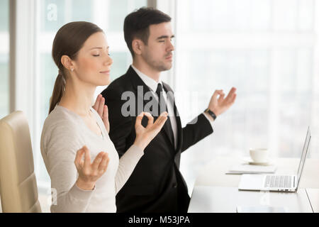 Young business leaders practice yoga at workplace Stock Photo