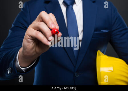 Male architect or constructor with yellow helmet  taking notes on empty screen Stock Photo