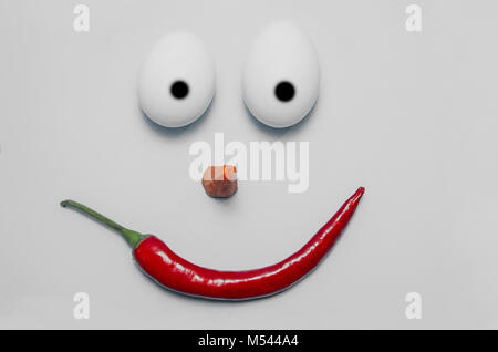 happy easter emoji from eggs, pepper, carrot and aloe on a gray background. Stock Photo