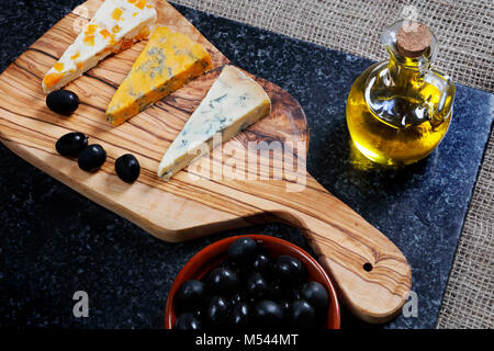 Dark Food - Blue Stiltons and Blue Shropshire cheeses on an olive wood board Stock Photo