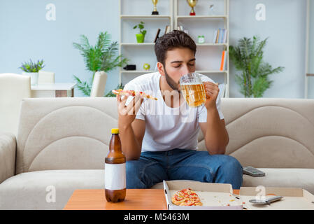 Man eating pizza having a takeaway at home relaxing resting Stock Photo