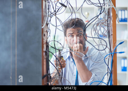 Electrician trying to untangle wires in repair concept Stock Photo