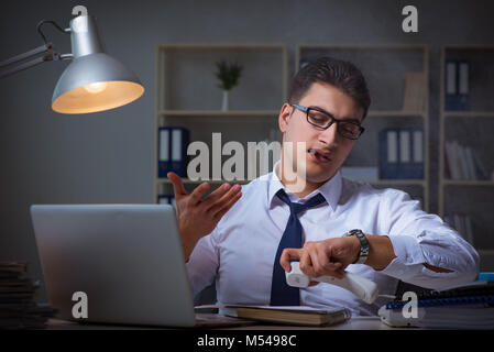 Businessman speaking on phone and smoking in office Stock Photo