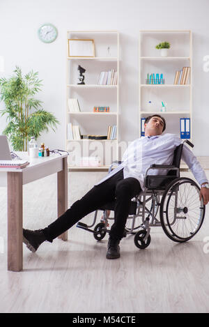 Doctor resting on wheelchair in hospital after night shift Stock Photo