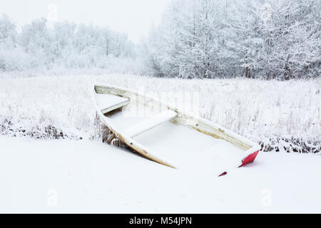 Rowing boat on the beach in snowy scenes Stock Photo