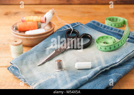 Sewing tools hobby, set of tailor on a wooden table, spools of thread, a steel thimble, selective focus Stock Photo