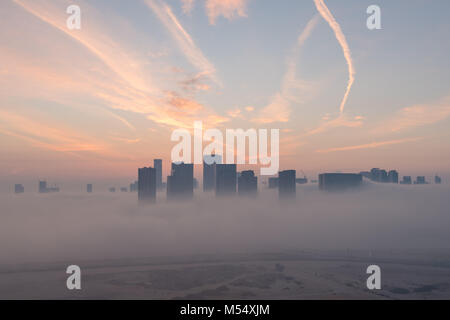 Abu Dhabi foggy sunrise. Morning view of high rise buildings on Reem Island in Abu Dhabi, capital city of the United Arab Emirates Stock Photo