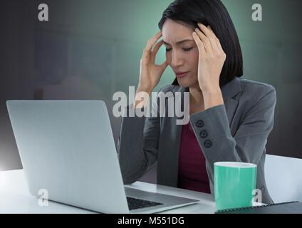 Businesswoman working on laptop with green background Stock Photo