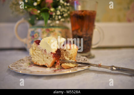 afternoon tea with vintage floral crockery scone cream and jam Stock Photo