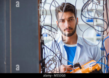 Electrician trying to untangle wires in repair concept Stock Photo