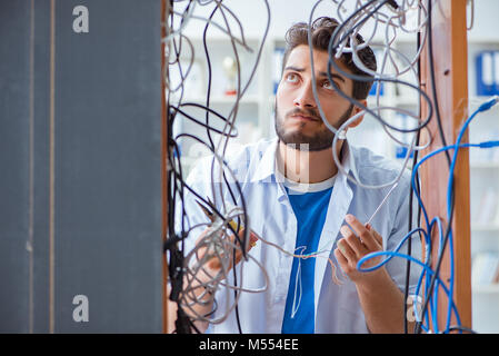 Electrician trying to untangle wires in repair concept Stock Photo