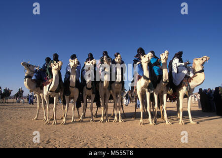 Algeria. Near Tamanrasset. Sahara desert. Men of Tuareg tribe on their camels. Indigo blue turbans. Stock Photo