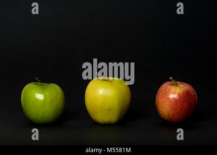 Three apples.  Green, yellow and red apples isolated in studio shot on black background Stock Photo
