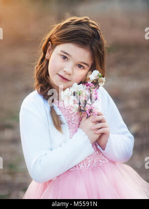 Little Girl with almond flowers in the gardens Stock Photo