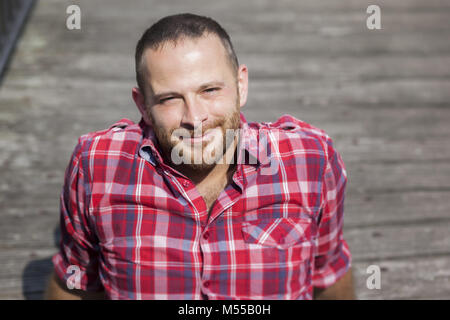 bearded handsome man relaxing outdoors in the sun Stock Photo
